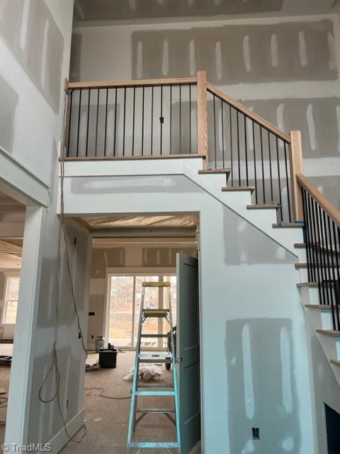 stairs with a towering ceiling and plenty of natural light