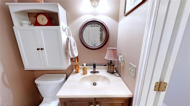 bathroom featuring toilet and vanity