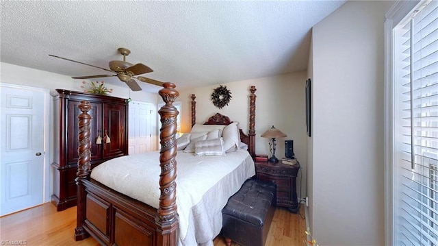 bedroom featuring light wood-style floors, a textured ceiling, and a ceiling fan