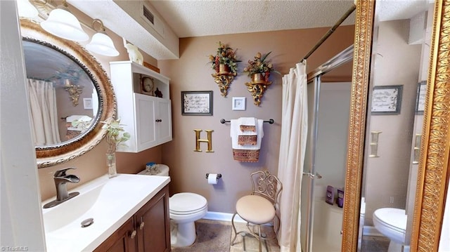 full bath featuring toilet, a stall shower, vanity, and a textured ceiling