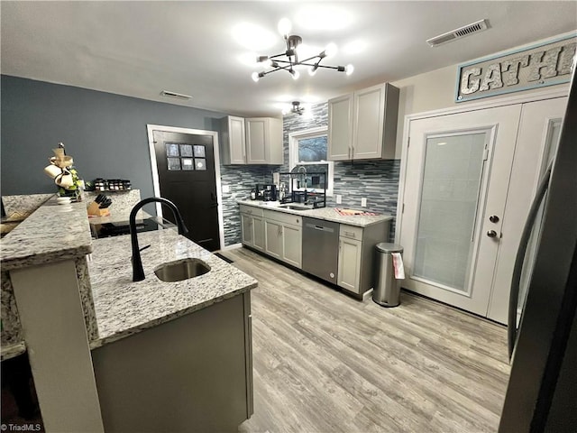 kitchen featuring gray cabinets, dishwasher, sink, and an inviting chandelier