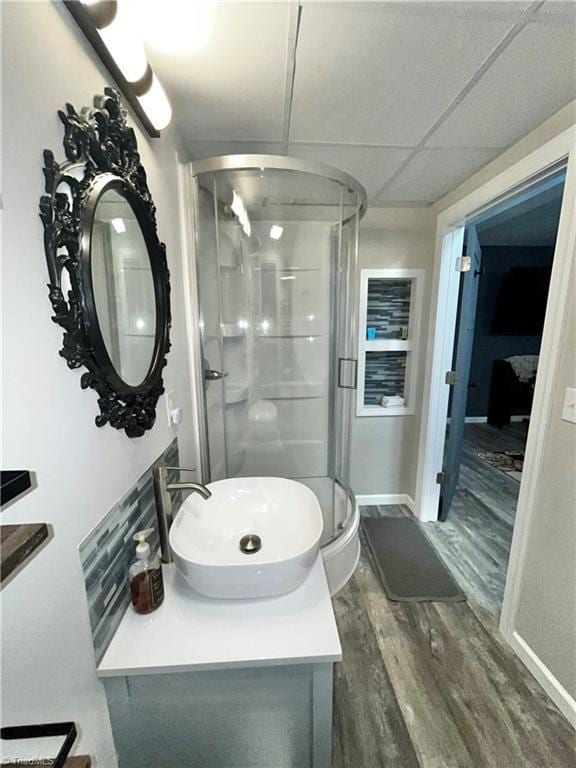 bathroom featuring a paneled ceiling, vanity, wood-type flooring, and an enclosed shower