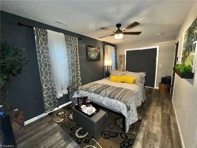 bedroom with dark hardwood / wood-style flooring and ceiling fan