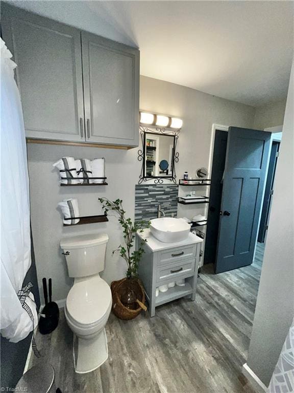 bathroom with hardwood / wood-style floors, vanity, and toilet