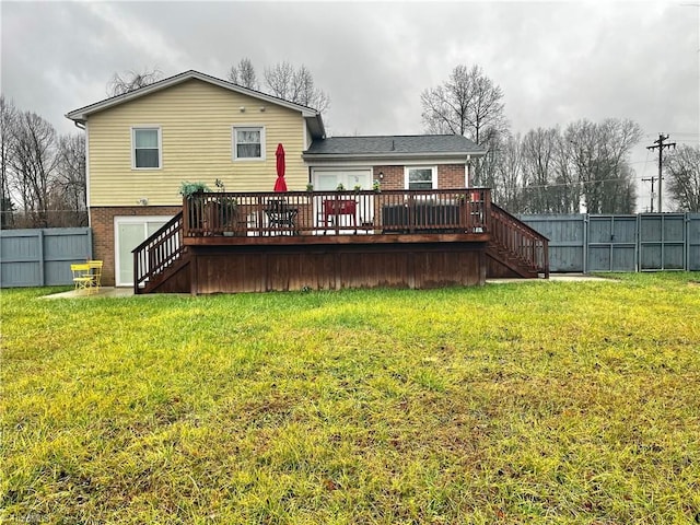 back of property with a yard and a wooden deck