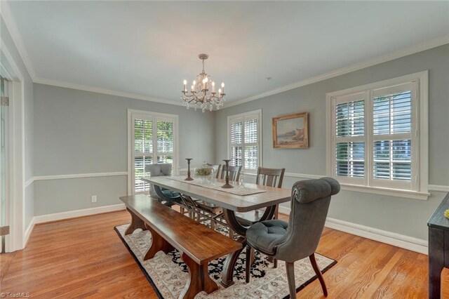 dining space with baseboards, a chandelier, ornamental molding, and light wood-type flooring