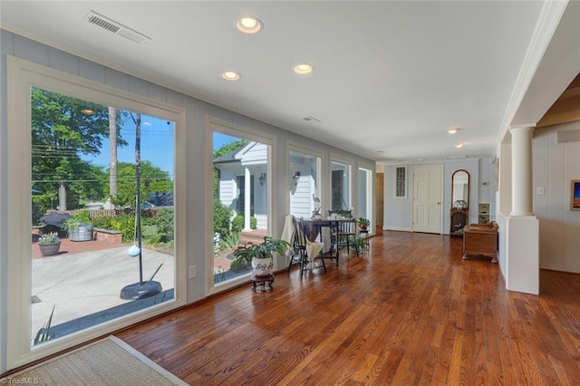interior space with visible vents, crown molding, decorative columns, wood finished floors, and recessed lighting