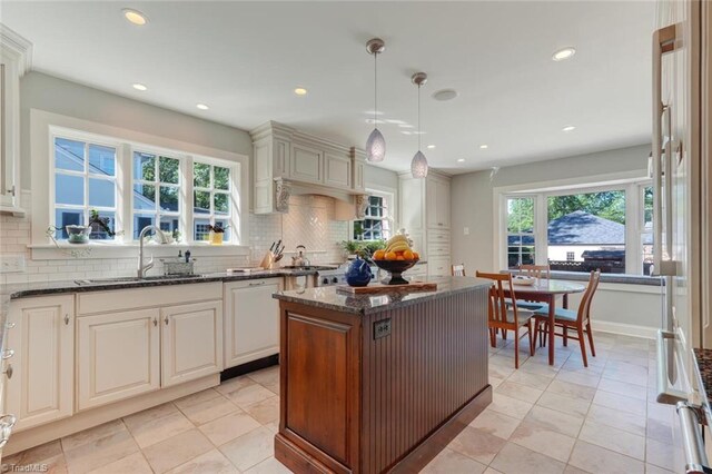 kitchen featuring recessed lighting, a sink, dark stone countertops, and tasteful backsplash