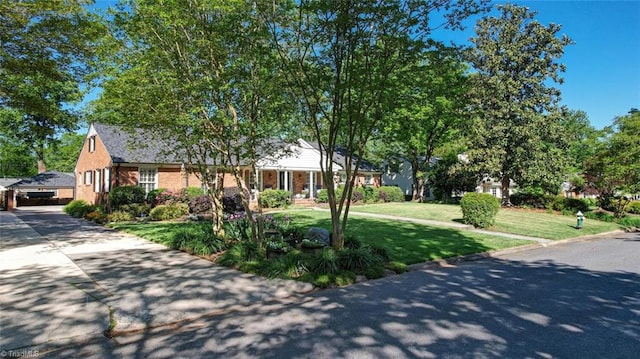 ranch-style house with concrete driveway and a front lawn