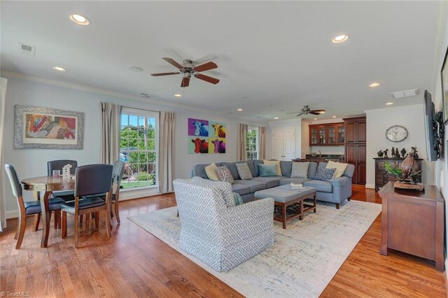 living room with recessed lighting, ornamental molding, ceiling fan, and visible vents