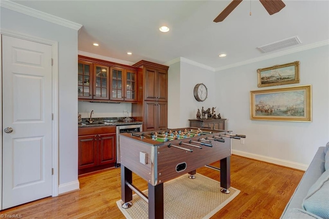 game room with visible vents, a sink, crown molding, and indoor wet bar