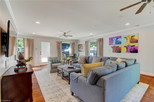 living area with ornamental molding and a ceiling fan