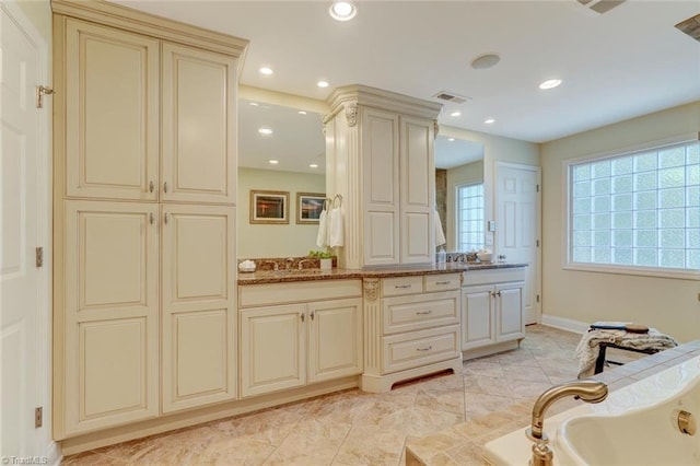 full bath with double vanity, visible vents, baseboards, recessed lighting, and a tub to relax in