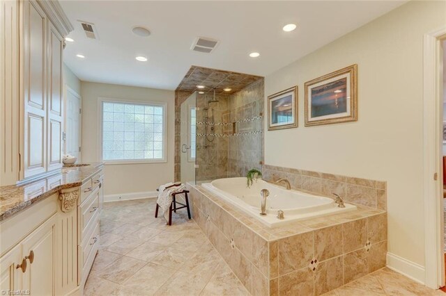 full bath featuring baseboards, a garden tub, a stall shower, and visible vents
