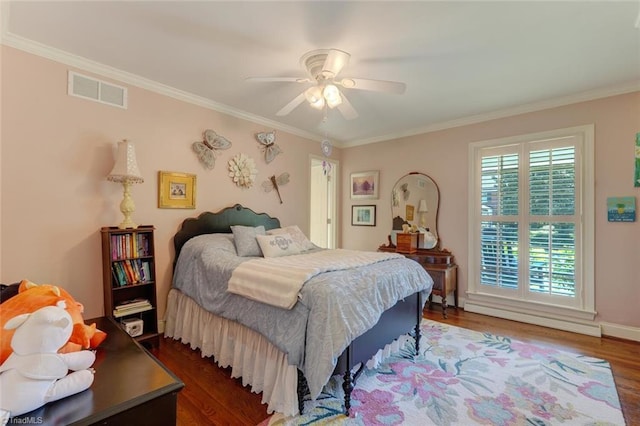 bedroom with ornamental molding, a ceiling fan, wood finished floors, and visible vents