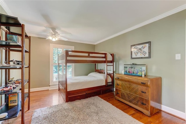 bedroom featuring crown molding, baseboards, and wood finished floors
