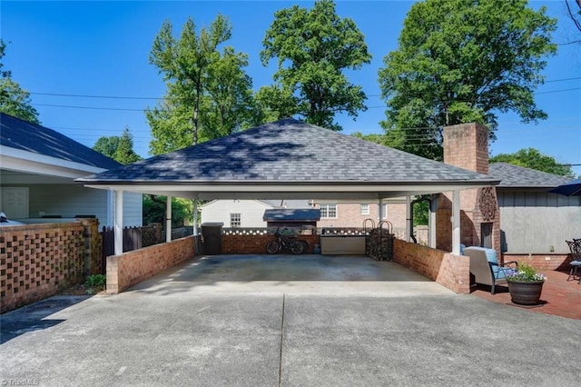 exterior space featuring fence, a carport, and driveway