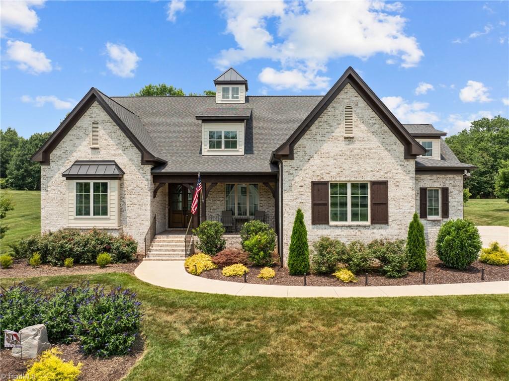 view of front of home featuring covered porch and a front lawn