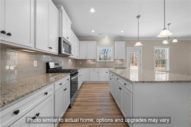 kitchen featuring stainless steel appliances, white cabinetry, and a center island