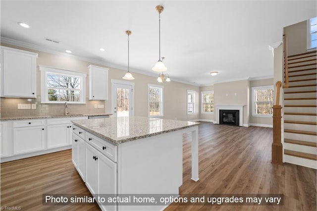 kitchen with tasteful backsplash, light wood-type flooring, a center island, and a wealth of natural light