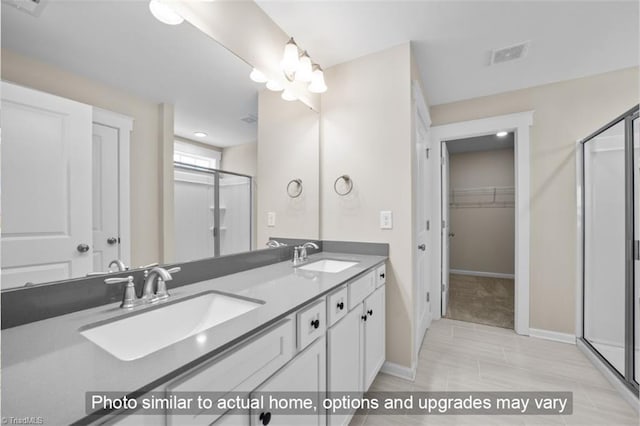 full bath with double vanity, a sink, visible vents, and a shower stall