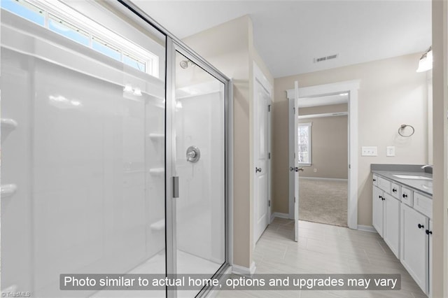 full bathroom with baseboards, visible vents, a shower stall, and vanity