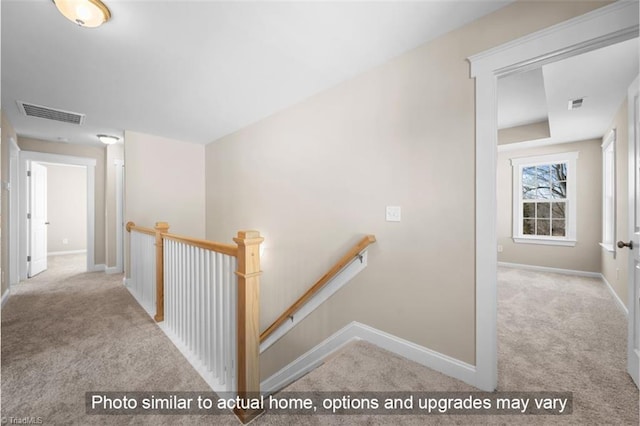 hallway featuring visible vents, carpet flooring, and an upstairs landing