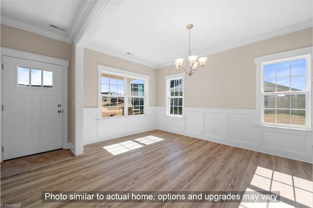 entryway with wood finished floors, a wealth of natural light, and a notable chandelier