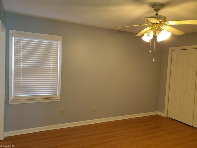 unfurnished bedroom featuring hardwood / wood-style flooring, a closet, and ceiling fan