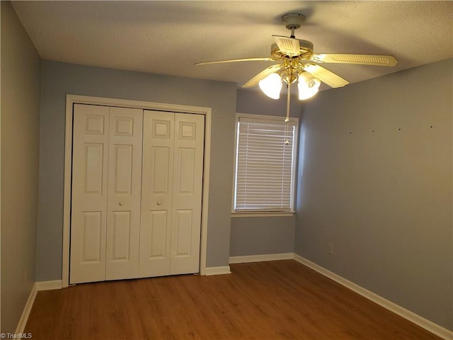 unfurnished bedroom featuring hardwood / wood-style floors, a textured ceiling, a closet, and ceiling fan