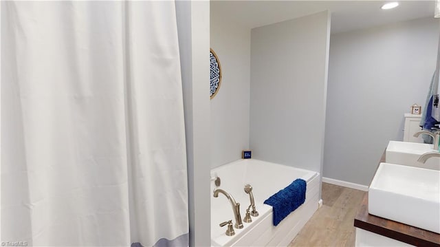 bathroom featuring a bath, vanity, and hardwood / wood-style flooring