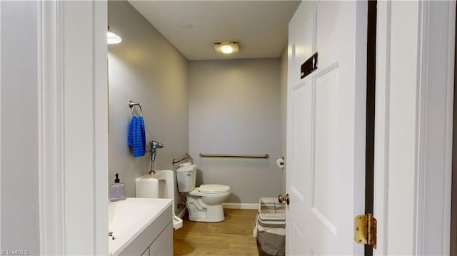 bathroom featuring toilet, hardwood / wood-style flooring, and vanity