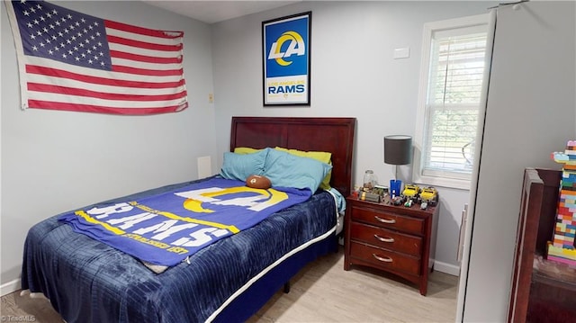 bedroom with multiple windows and light hardwood / wood-style flooring