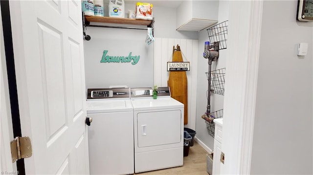 laundry room with independent washer and dryer and light wood-type flooring