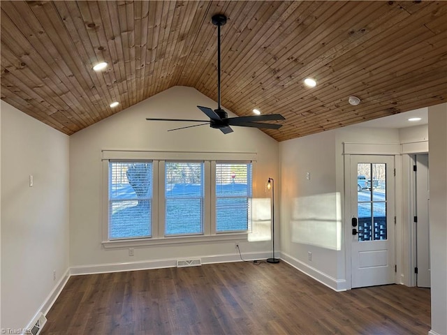 unfurnished room with dark wood-style floors, a wealth of natural light, visible vents, and vaulted ceiling