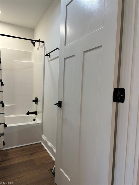 bathroom with bathing tub / shower combination and wood finished floors