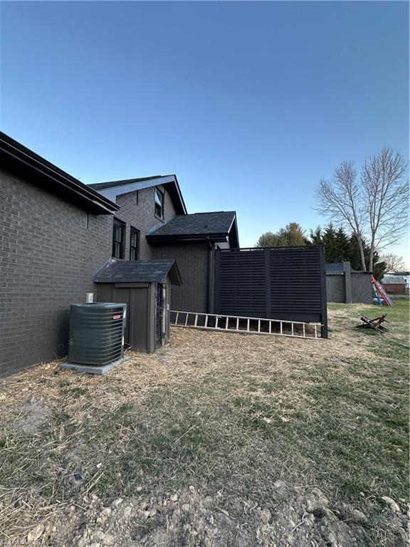 view of yard featuring cooling unit and fence