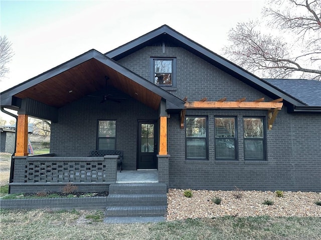 view of front of house featuring a porch and brick siding