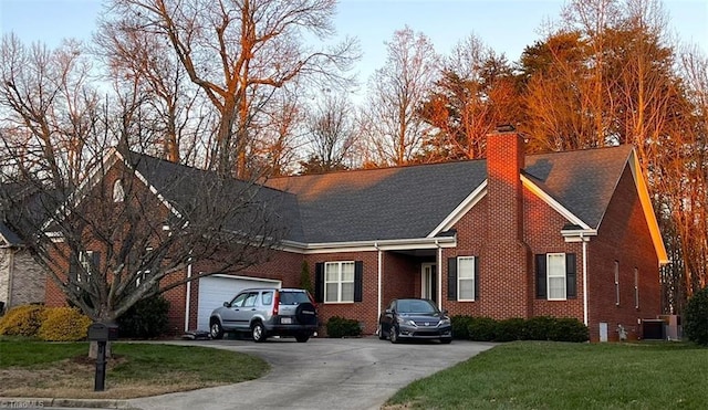 view of front of house featuring a garage, a front yard, and central AC