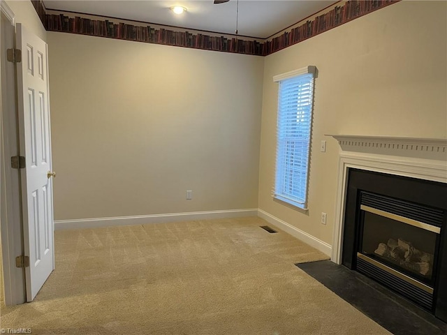 unfurnished living room featuring carpet floors and ceiling fan