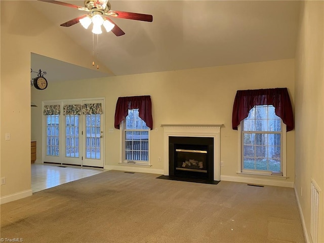 unfurnished living room with ceiling fan, carpet floors, a healthy amount of sunlight, and high vaulted ceiling