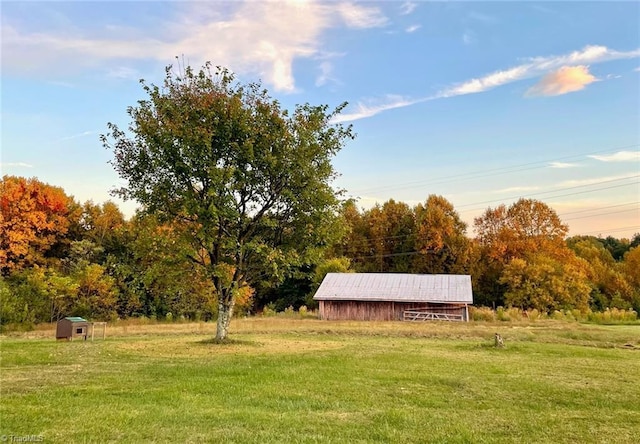 view of community featuring a lawn and an outdoor structure