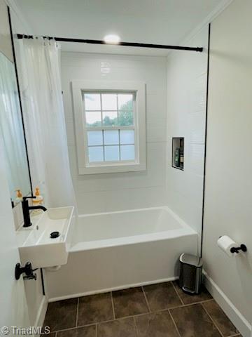 bathroom featuring a sink, tile patterned flooring, shower / bath combo with shower curtain, and baseboards