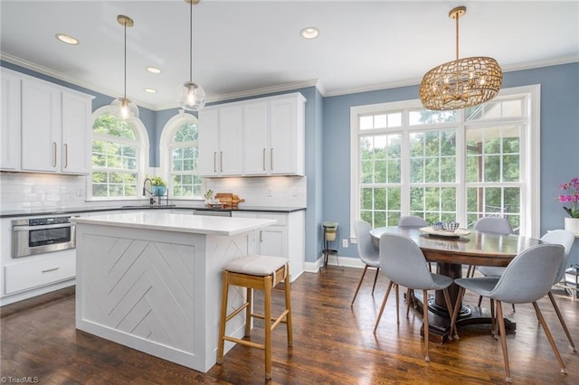 612 Wigeon Dr, Greensboro, NC 27455 - kitchen featuring oven, ornamental molding, tasteful backsplash, a kitchen island, and recessed lighting