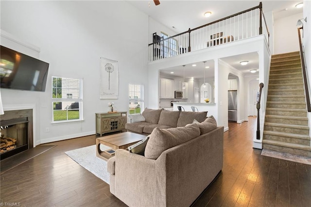 4 Harvest Oak Ct, Greensboro, NC 27406 - living room with stairs, dark wood finished floors, a fireplace, a towering ceiling, and plenty of natural light