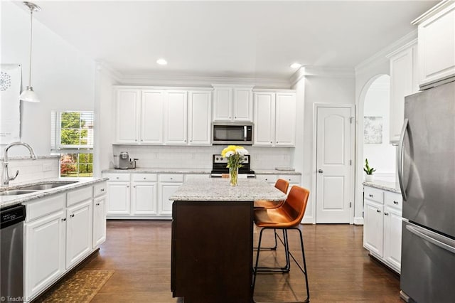 4 Harvest Oak Ct, Greensboro, NC 27406 - kitchen with appliances with stainless steel finishes, a sink, a kitchen island, white cabinetry, and ornamental molding