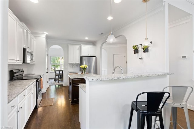 4 Harvest Oak Ct, Greensboro, NC 27406 - kitchen featuring appliances with stainless steel finishes, arched walkways, recessed lighting, tasteful backsplash, and dark wood-style floors