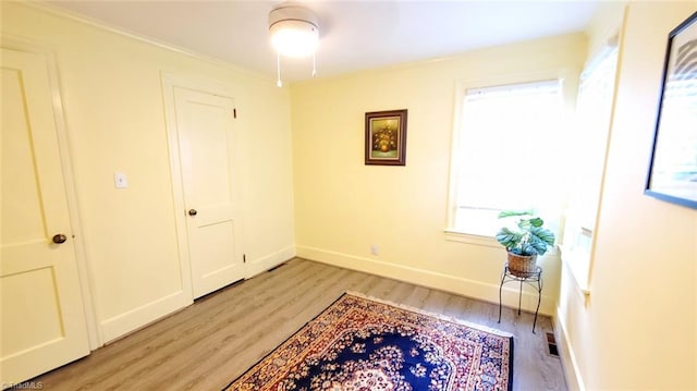 interior space with light hardwood / wood-style floors and ornamental molding