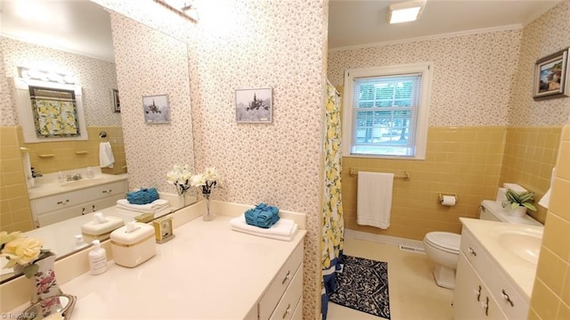 bathroom featuring vanity, toilet, crown molding, and tile walls