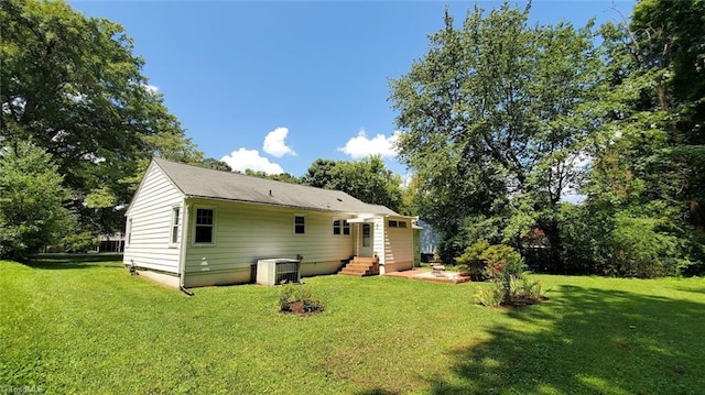 back of house featuring a lawn and central AC